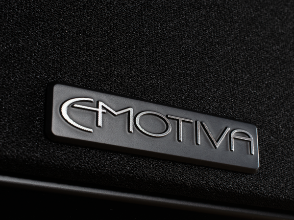 closeup photo of the Emotiva metal badge at the bottom of the Airmotiv X black  loudspeaker grill