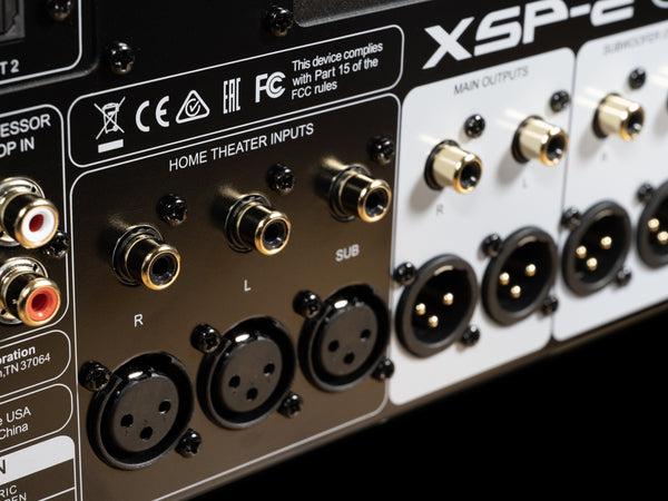 Close-up of audio equipment with various connectors and branding on a black background.